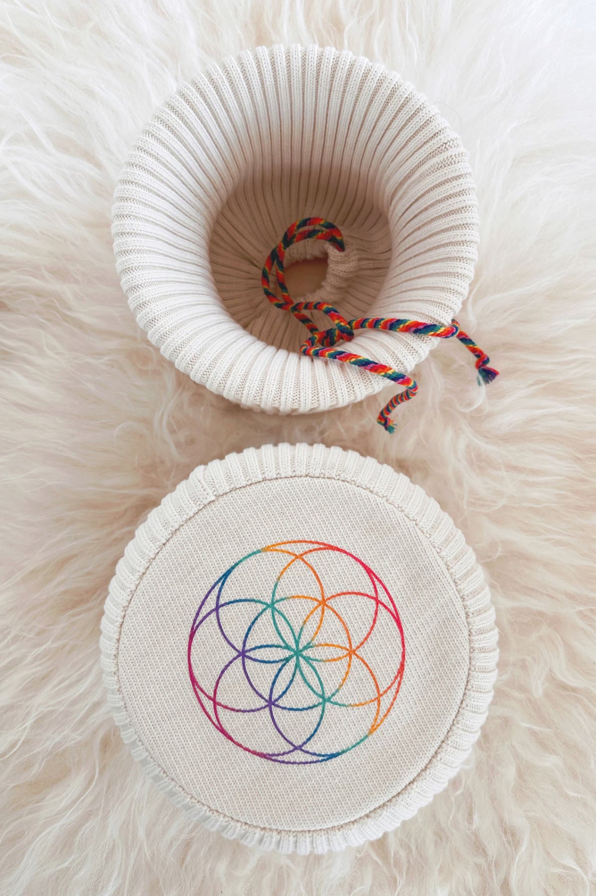 Eco-Luxe singing bowl cover showing 2x2 ribbed knit texture and flower of life base with chakra drawstring